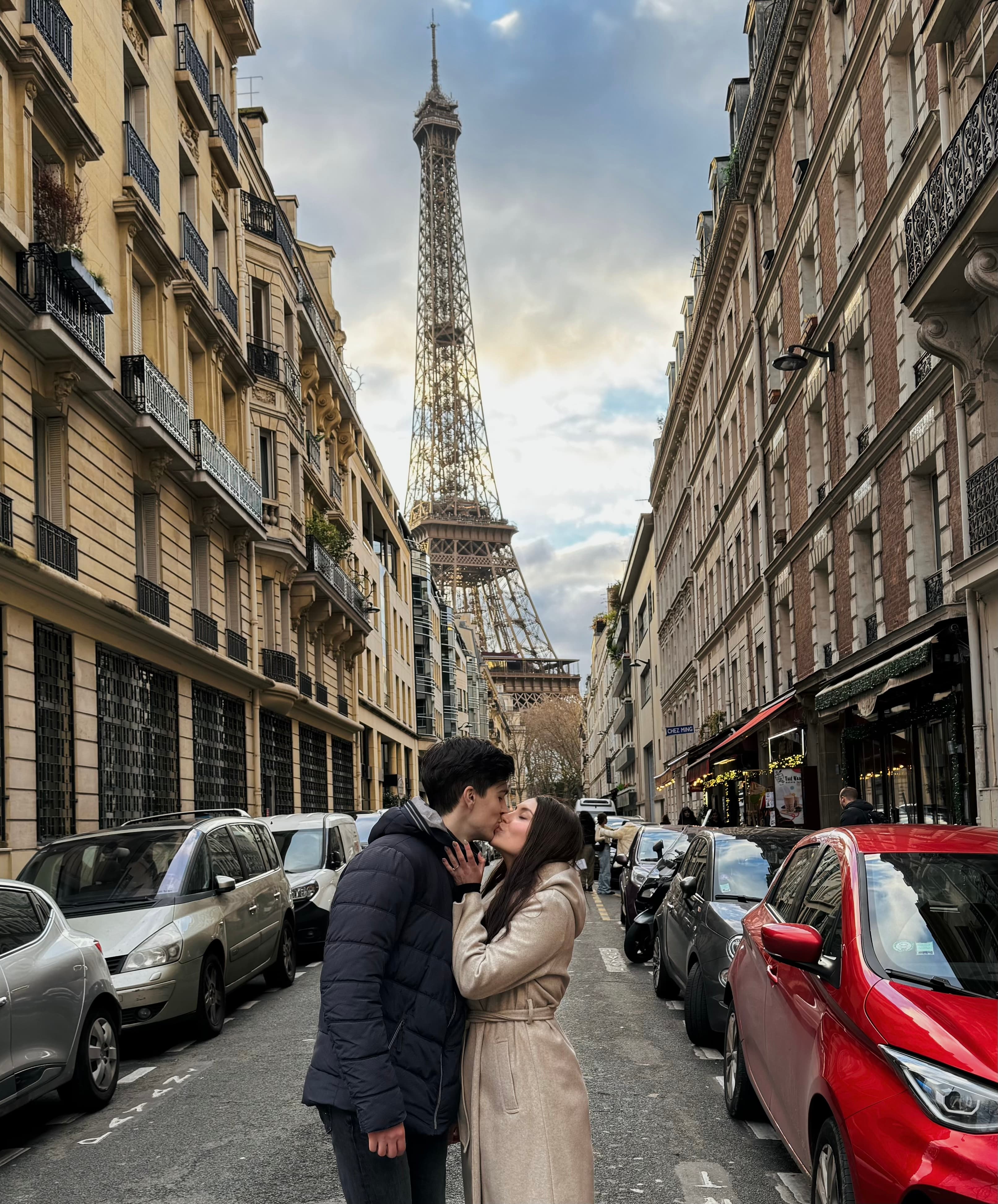 Couple kissing with a view of the Eiffel Tower in Paris